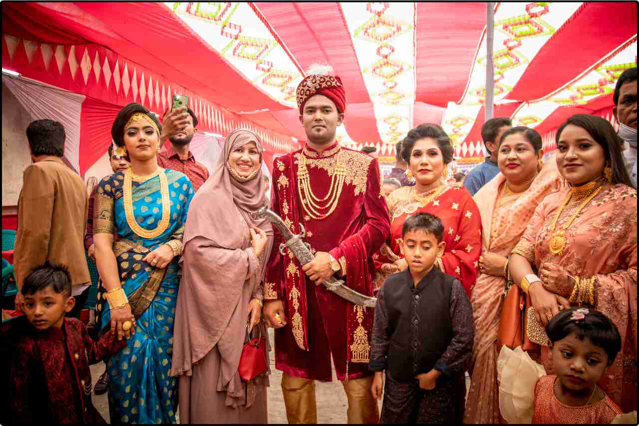 Family members in elaborate cultural dress,with big knife in hand standing proudly at a wedding celebration